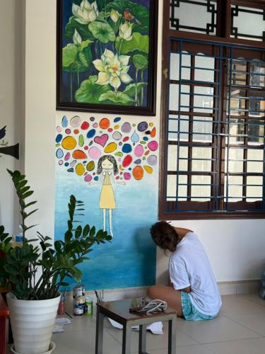 a person sitting on the floor next to a table at Cheerful Hoi An Hostel in Hoi An