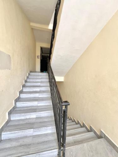 a staircase in a building with a metal railing at Jnjzhomes Mombasa in Mombasa