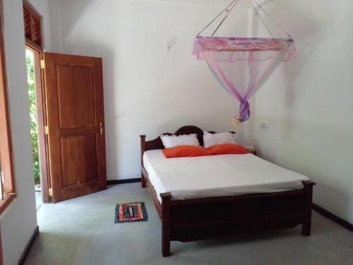 a bedroom with a bed in a room with a door at Villa Ameliya in Unawatuna