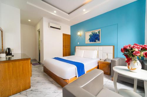 a hotel room with a bed and a table at Collection O Sunrise Hotel Trung Son Near Lotte Mart in Ho Chi Minh City