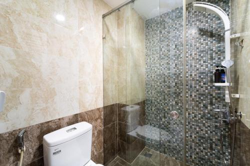 a bathroom with a toilet and a glass shower at Collection O Sunrise Hotel Trung Son Near Lotte Mart in Ho Chi Minh City