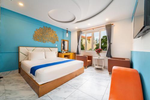 a bedroom with a bed and a blue wall at Collection O Sunrise Hotel Trung Son Near Lotte Mart in Ho Chi Minh City