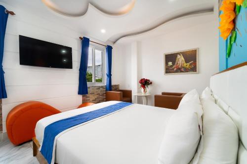 a bedroom with a bed and a tv on the wall at Collection O Sunrise Hotel Trung Son Near Lotte Mart in Ho Chi Minh City
