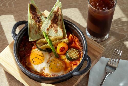 a bowl of food with eggs and crackers and a drink at Humble Boutique Hotel in Taipei
