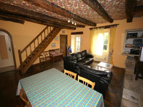 a living room with a couch and a table at Holiday Home in Saint-Geniez-d'Olt near Lot River in Saint-Geniez-dʼOlt