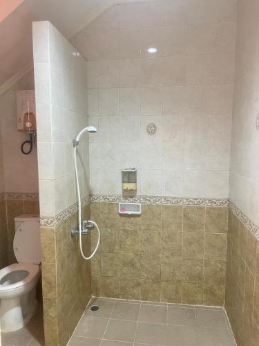 a bathroom with a shower and a toilet at Kota bunga in Cikundul