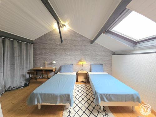 a bedroom with two beds and a table and a window at Maison spacieuse Périgord Pourpre avec piscine partagée - FR-1-616-498 in Monsaguel