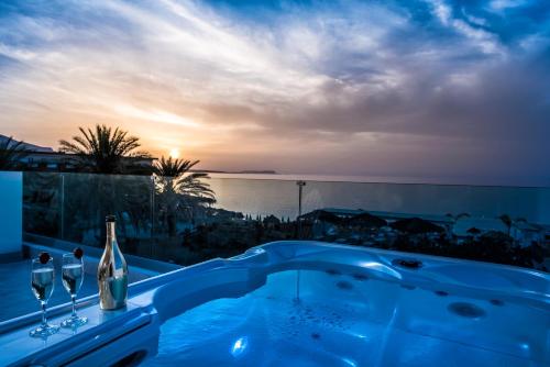 a hot tub with a view of the ocean at Drossia Palms Hotel and Nisos Beach Suites in Malia