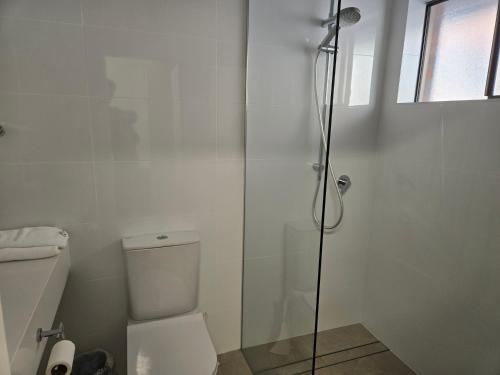 a white bathroom with a shower and a toilet at Best Western Parkside Motor Inn in Coffs Harbour