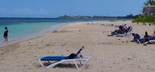 a group of people sitting in lawn chairs on a beach at Ocean Tropical Escape 1BR 1BA Ocean view in Runaway Bay