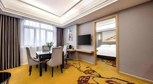 a hotel room with a dining table and a bedroom at Vienna Hotel Zhejiang Lishui Qingtian Post Building in Lishui