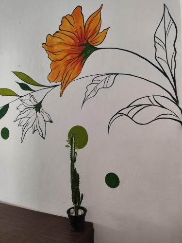 a drawing of a flower and a cactus on a wall at Pousada Ray Sol - Centro Arraial d Ajuda in Arraial d'Ajuda
