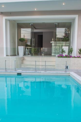 a swimming pool with blue water in front of a building at Lefkadio in Lefkada Town