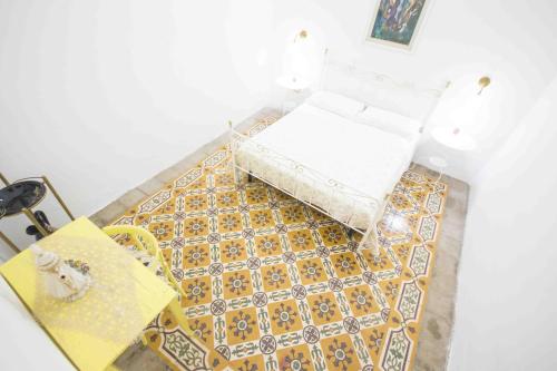 a room with a bed and a yellow and white floor at La Marea in Castro di Lecce