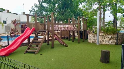 a playground with a red slide and a ladder at Victoria Comfort Condo in Playa del Carmen