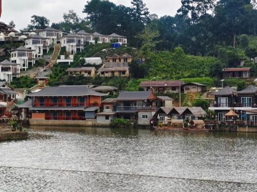 a group of houses next to a body of water at ม่านหมอก รักไทย ManMork RakThai in Ban Rak Thai