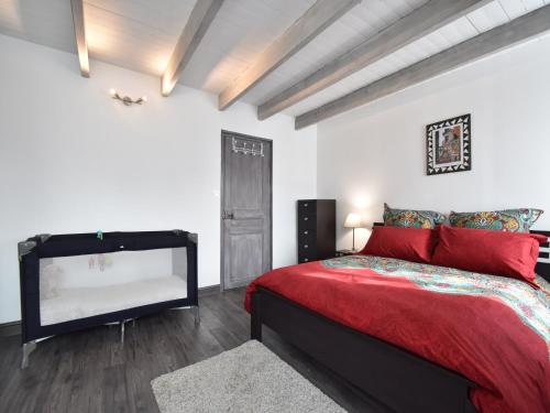 Quiet Normandy Retreat في Saint-Rémy-des-Landes: غرفة نوم بسرير ومخدات حمراء