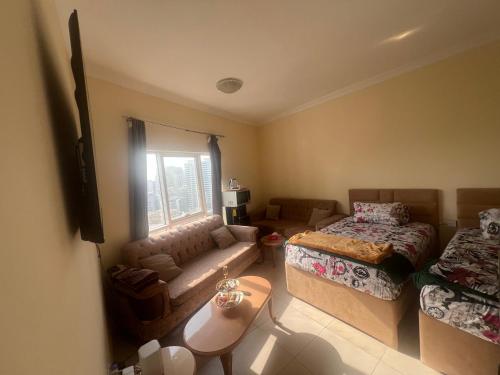 a living room with a couch and a bed at AlNahda Border SHJ-DXB- 2BADROOM AND HALL FULL FLAT FOR YOU ONLY in Sharjah