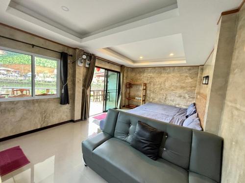 a living room with a couch and a bed at ม่านหมอก รักไทย ManMork RakThai in Ban Rak Thai