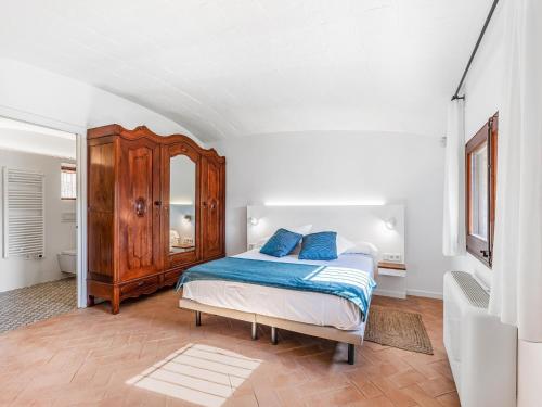 a bedroom with a bed and a wooden cabinet at Charming Home Near Vulpellac in Vulpellac