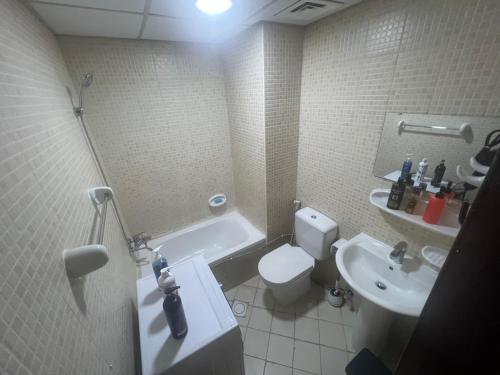 a bathroom with a white toilet and a sink at AlNahda Border SHJ-DXB- 2BADROOM AND HALL FULL FLAT FOR YOU ONLY in Sharjah