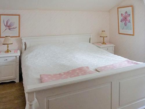 a bedroom with a white bed with two night stands at 6 person holiday home in TROLLHÄTTAN in Trollhättan