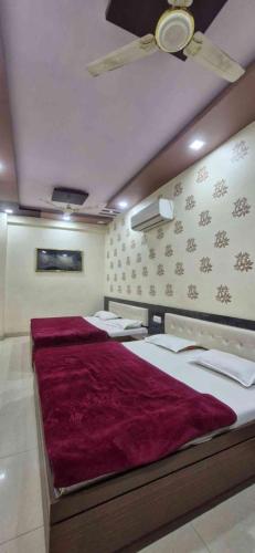 a bedroom with a large bed with a red blanket at Hotel ganga in Ajmer