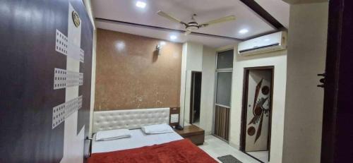 a bedroom with a red bed and a mirror at Hotel ganga in Ajmer