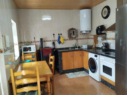 a kitchen with a table and a stove top oven at La Guaja vivienda de uso turístico in Olleros de Sabero
