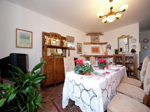 ein Esszimmer mit einem Tisch mit Blumen darauf in der Unterkunft Woodland Escape with Pool in Carbuta