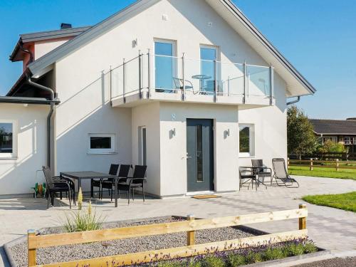 a house with a balcony and a table and chairs at 5 star holiday home in Glommen in Falkenberg