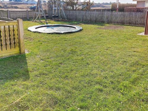 a backyard with a trampoline in the grass at 10 person holiday home in Thisted-By Traum in Klitmøller