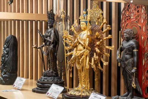 eine Gruppe von Statuen, die auf einem Tisch sitzen in der Unterkunft Temple Town Hotel WAQOO Horyuji in Ikaruga