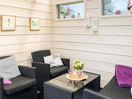 a patio with two chairs and a table with flowers at 6 person holiday home in FIGEHOLM-By Traum in Figeholm