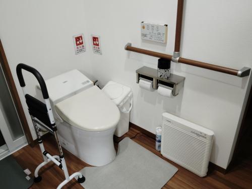 Barrier Free Guesthouse Support Included في أوساكا: حمام مرحاض ابيض وراديتور