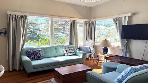 a living room with a blue couch and a large window at Twin Dolphins 1, 1 - 18 Clarence St in Yamba