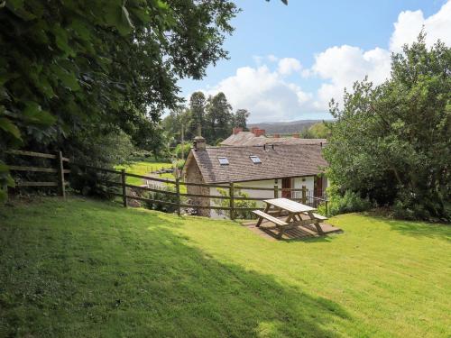 a picnic table in a field in front of a house at Abbots Reading Suite in Lake Side