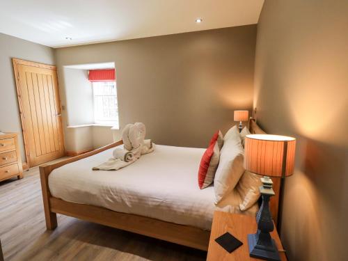 a bedroom with a bed with a stuffed animal on it at Abbots Reading Mews 1 in Lake Side