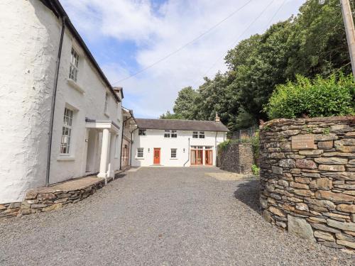 an exterior view of a white house with a stone wall at Abbots Reading Mews 1 in Lake Side