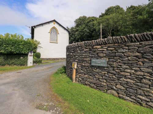 a stone wall next to a church with a building at Abbots Reading Mews 1 in Lake Side