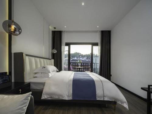 a bedroom with a bed and a balcony at Fenghuang Ancient Town Tinglan Waterfront High-end B&B in Fenghuang