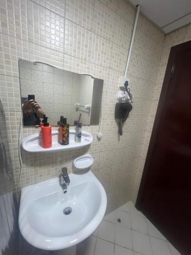 a bathroom with a sink and a mirror at AlNahda Border SHJ-DXB -ZAMAZM GuestHouse in Sharjah