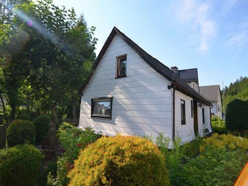 a white house with a black roof in a garden at Holiday home in Ramsbeck with garden in Ramsbeck
