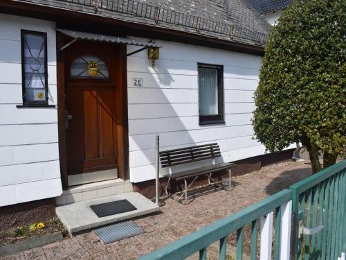 a door to a house with a bench in front at Holiday home in Ramsbeck with garden in Ramsbeck