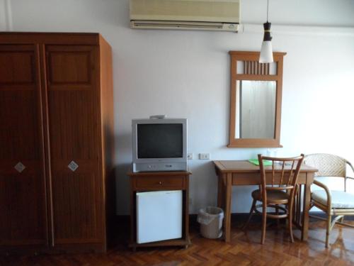 a living room with a television and a table with chairs at Baiyoke Chalet Hotel in Mae Hong Son
