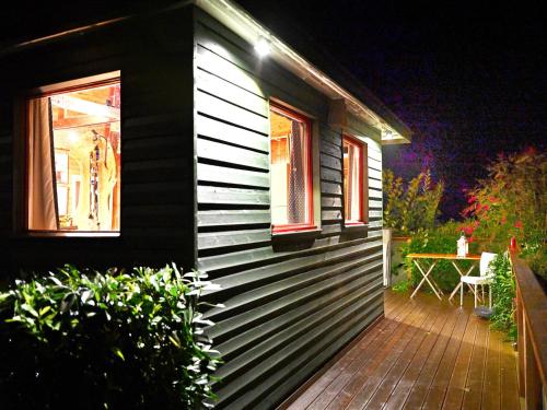 a house with a wooden deck with a table on it at Chalet in Sougnי-Remouchamps in Aywaille