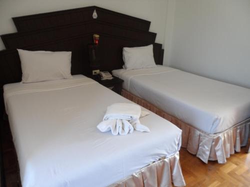 dwa łóżka z białymi rękawiczkami siedzące na nich w obiekcie Baiyoke Chalet Hotel w mieście Mae Hong Son