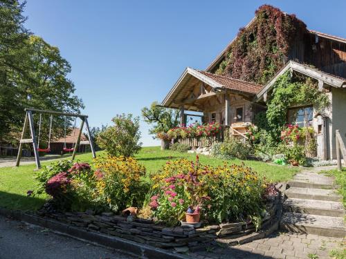 a house with a bunch of flowers in front of it at Alpiner Aufenthalt mit Balkon in Steingaden in Steingaden