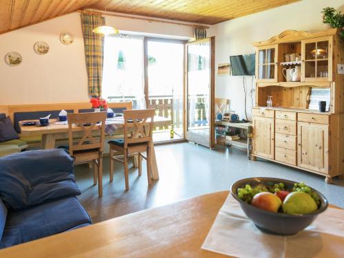 a living room with a table with a bowl of fruit at Alpiner Aufenthalt mit Balkon in Steingaden in Steingaden