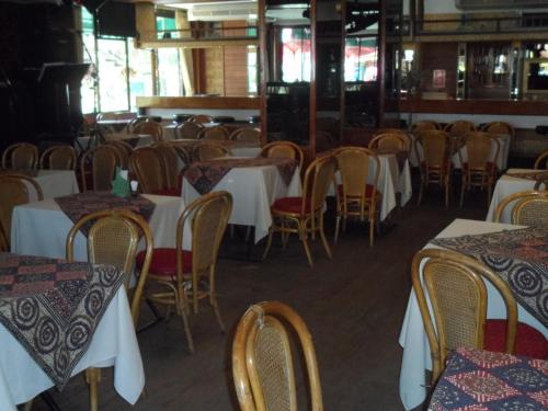 a dining room with white tables and chairs at Baiyoke Chalet Hotel in Mae Hong Son
